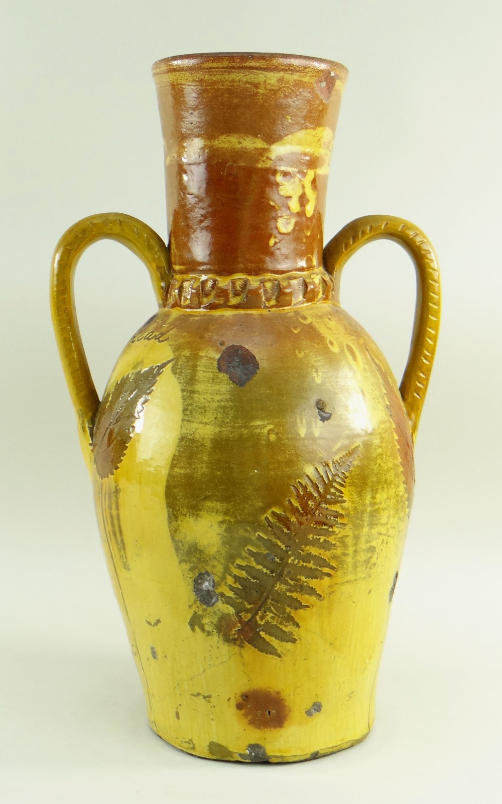 A 19TH CENTURY SLIPWARE POTTERY TWIN HANDLED VASE with elongated neck and two loop handles, clear - Image 2 of 2