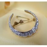 YELLOW & WHITE METAL DIAMOND CRESCENT BROOCH, set with nineteen graduated diamonds, 7.8gms