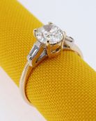 18CT GOLD DIAMOND RING, the central stone (0.7cts approx.) flanked by diamond tapering baguette