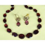 GARNET SET RIVIERE NECKLACE, the thirty graduated oval-shaped stones closed set in yellow metal,