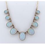 9CT GOLD OPAL NECKLACE, having nine oval graduated opals, the largest measuring 13 x 10mms, 50cms