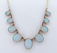 9CT GOLD OPAL NECKLACE, having nine oval graduated opals, the largest measuring 13 x 10mms, 50cms