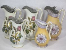 ANTIQUE JUGS (5) - a set of three having pewter lidded mounts and briar rose transfer decoration and