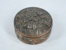 A CIRCULAR ORIENTAL LIDDED COPPERIZED TRINKET BOX - the lid of raised flowers on lattice work and