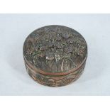 A CIRCULAR ORIENTAL LIDDED COPPERIZED TRINKET BOX - the lid of raised flowers on lattice work and