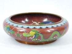 A CIRCULAR EARLY 20TH CENTURY CLOISONNE SHALLOW BOWL - 24cms diameter, 8cms H, decorated with blue