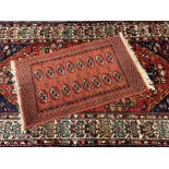 VINTAGE EASTERN RUGS (2) - a fine Bukhari rug, red ground with repeating central block pattern and
