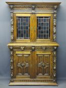 CONTINENTAL STYLE CARVED OAK BOOKCASE SIDEBOARD - with leaded coloured glass upper doors, lion mask,