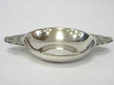 A SMALL SILVER BONBON/SWEETMEATS DISH with floral and Celtic style patterned shaped handles,