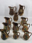 VICTORIAN COPPER LUSTRE JUGS (11) - having painted relief moulded floral detail in the main, two