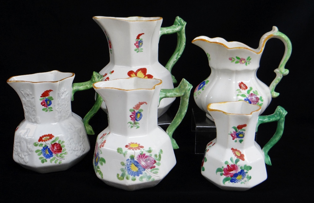 FIVE SWANSEA POTTERY JUGS including graduated trio, all with green twig-handles, enamelled flowers