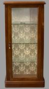 REPRODUCTION MAHOGANY SINGLE DOOR DISPLAY CABINET with interior glass shelves, on a plinth base,