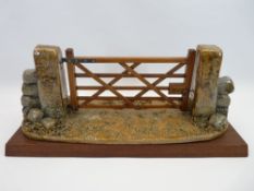 R C WARD LLANGAFFO POTTERY & WOOD SCULPTURE - signed and dated 1989 of a five bar gate between stone