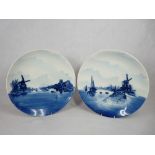 ROSENTHAL BLUE & WHITE DELFT WALL CHARGERS, A PAIR - typically decorated Dutch scenes with