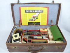 TRIX TWIN RAILWAY - boxed engines, track and trailer, ETC, all within an old leather suitcase