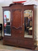 CIRCA 1900 MAHOGANY COMBINATION WARDROBE having a shaped top cornice over twin outer bevelled edge