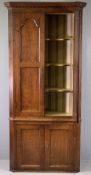 ANTIQUE OAK FLOORSTANDING CORNER CUPBOARD, having dentil cornice over twin shaped panelled doors and