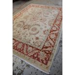 PERSIAN-STYLE IVORY & CORAL RUG, pale floral field within coral border of palmettes and serrated