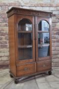 ANGLO-INDIAN STYLE CARVED HARDWOOD CABINET, arched bevel glazed doors, apron drawers, reeded bun