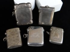 FIVE SIMILAR SILVER VESTA CASES of rectangular form, two plain, three engraved including 'H. M. S.