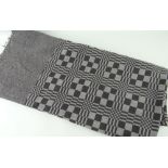 AN ANTIQUE WELSH NARROW LOOM COARSE WOOL BLANKET, in grey ground with tessellated design, 170 x