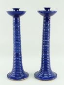 A PAIR OF EWENNY POTTERY TALL CANDLESTICKS circular based with ribbed tapering stems, bowl shaped