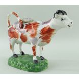 SWANSEA PEARLWARE COW CREAMER standing over a grassy rectangular base, iron-red and pink lustre