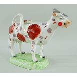 A RARE LLANELLY COW CREAMER in the familiar Swansea style with tail as loop handle and standing over