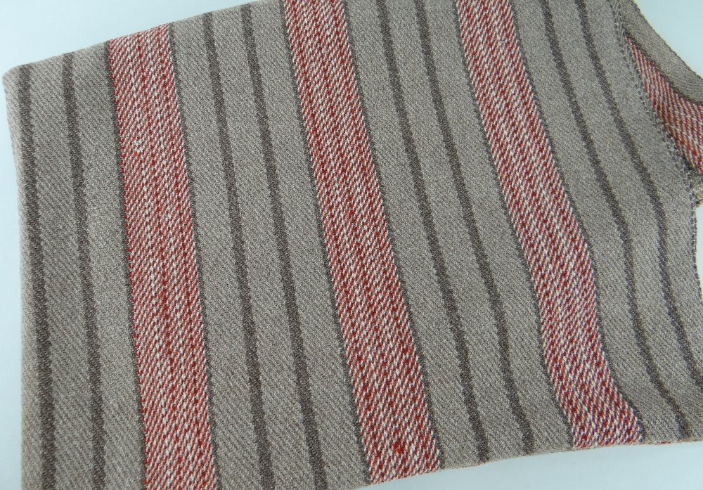 AN ANTIQUE WELSH NARROW LOOM COARSE WOOL BLANKET, in brown ground with flecked red bands and dark