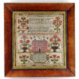 AN 1843 WELSH WOOL SAMPLER TO ELIZABETH EDWARDS, containing a series of flowers in vases around a