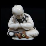 FINE JAPANESE STAINED & INLAID IVORY NETSUKE, Meiji Period, of a seated man contemplating his