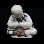 FINE JAPANESE STAINED & INLAID IVORY NETSUKE, Meiji Period, of a seated man contemplating his