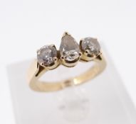 THREE STONE DIAMOND RING, having central pear cut diamond flanked by two round cut diamonds,