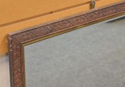 CARVED OAK WALL MIRROR, decorated with ribbon wrapped fruiting laurel in shallow relief, gilt