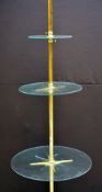 BRASS TIERED SHOP DISPLAY STAND, column supporting three graduated circular glass shelves, steel