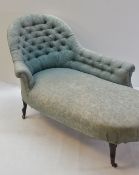 EDWARDIAN CHAISE LONGUE, spoon back and button upholstered in green damask material, on ebonised
