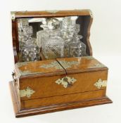 EDWARDIAN OAK TANTALUS, with plated mounts, mirror back and cigar box to the front (refitted),