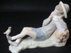 LLADRO - young reclining boy with bird at his foot, 19cms L, 13cms H
