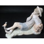 LLADRO - young reclining boy with bird at his foot, 19cms L, 13cms H