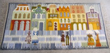 A POLISH KILIM RUNNER/THROW - colourful depiction of houses and figures, fringed ends with original