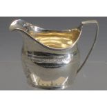 SILVER GEORGIAN CREAM JUG - with delicate leaf and other decoration and having a long ridged handle,