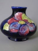 MOORCROFT 'CLEMATIS' SQUAT VASE, decorated on a cobalt blue ground, 7cms H, impressed factory