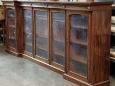 VICTORIAN MAHOGANY INVERTED BREAKFRONT BOOKCASE having three central glazed doors and two arched top