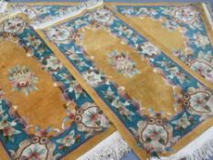 CHINESE WASHED WOOLLEN RUGS (3), orange ground with wide floral border against a blue background