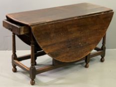 ANTIQUE OAK GATE LEG DINING TABLE, twin flap with planked top and single end drawer, on turned and