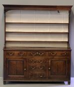 18th CENTURY NORTH WALES OAK DRESSER having a wide boarded rack with three shelves and shaped top