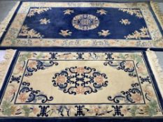 CHINESE WASHED WOOLLEN RUGS (2) - cream ground with blue borders and tasselled ends and multi-floral