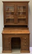 EDWARDIAN OAK SLOPED TOP PEDESTAL DESK with glazed bookcase top, inlaid detail to the top showing