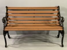 WOODEN SLATTED GARDEN BENCH with decorative cast iron ends having lion masks to the front, 76cms