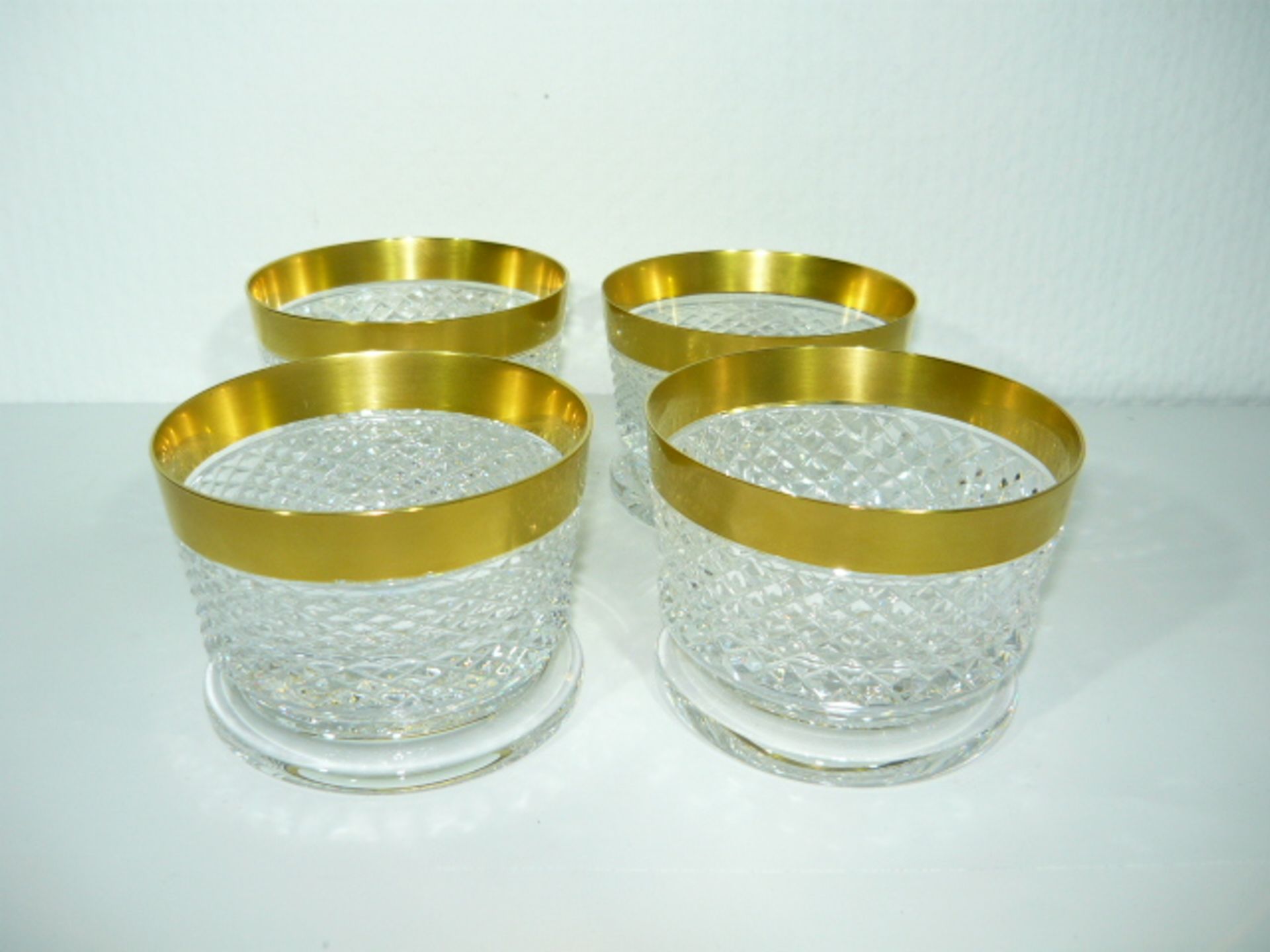 Satz von 4 schweren Trinkgläsern bzw Dessertschalen mit breitem Goldrand. Dm. 10,5cm, H. 7cm.